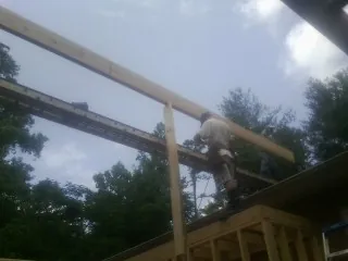 Carpenter setting a ridge beam over a new addition frame — Ice Dam Removal by Roofing Brothers in Warrensville