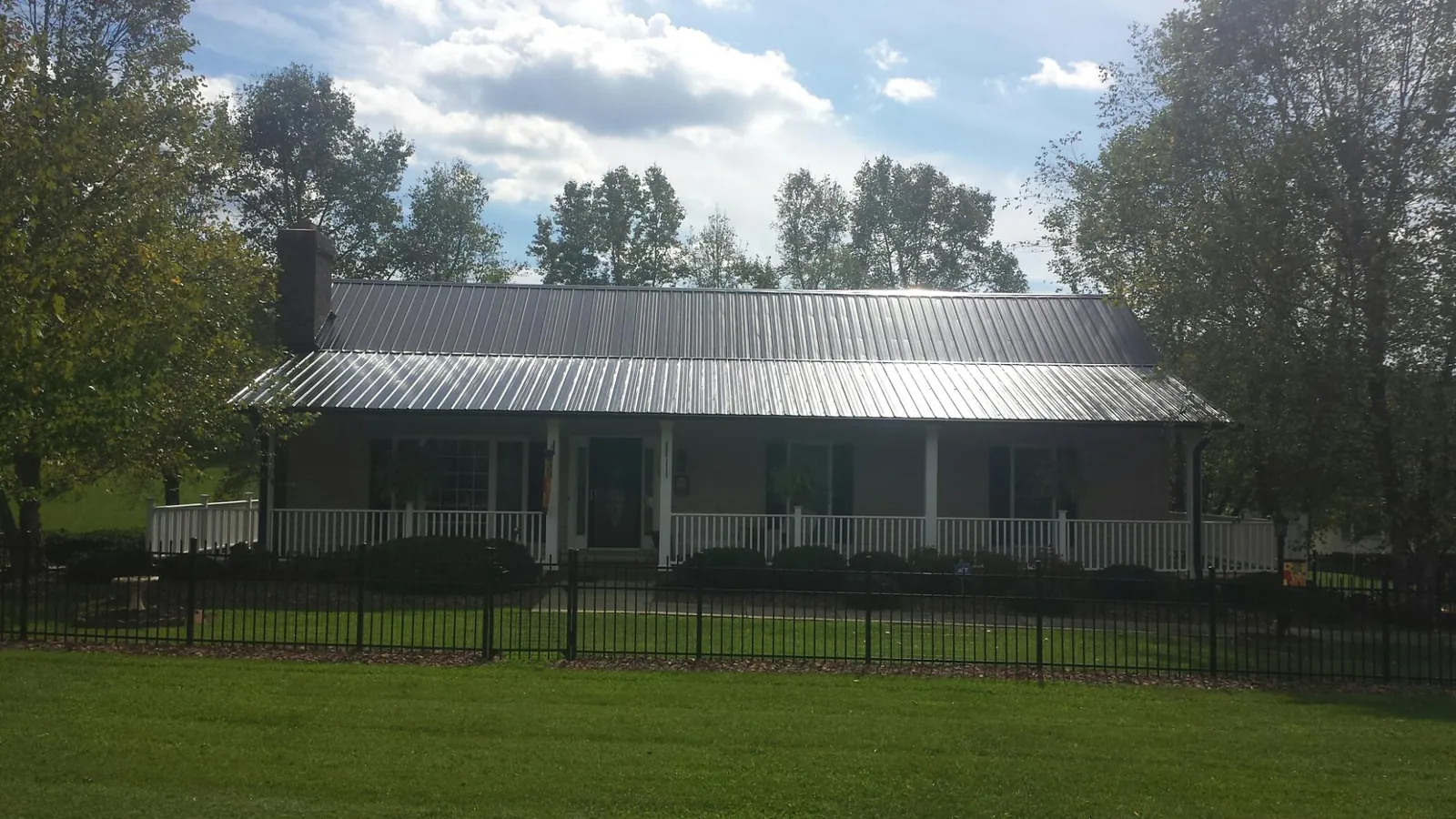 Gray metal roof on a brick ranch with a full width front porch — Gutter Guard Installation work by our crew in Warrensville