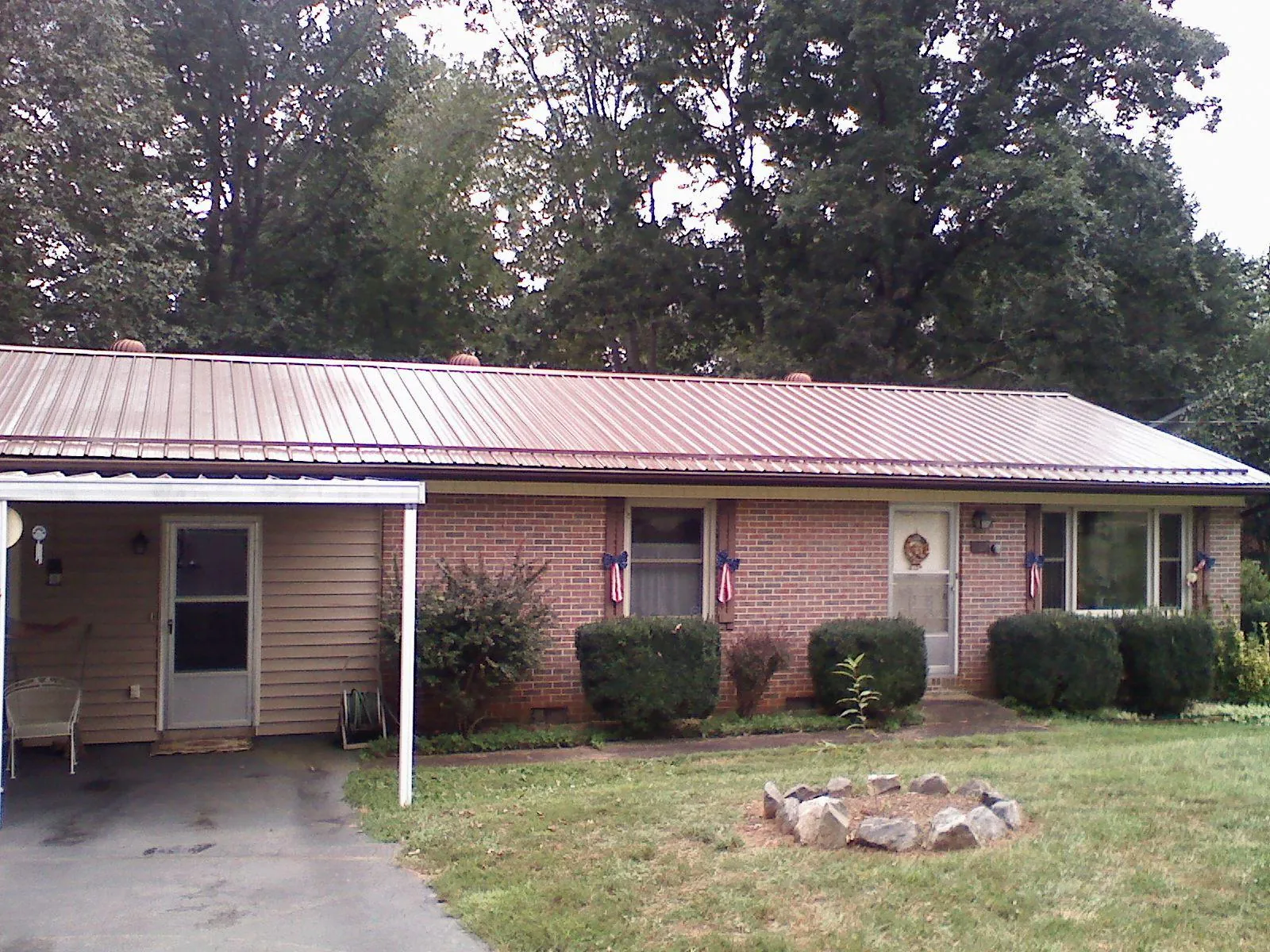 Bronze metal roof and carport on a brick ranch home — Roof Repair work by our crew in Warrensville